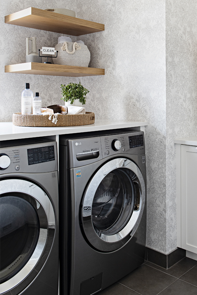 Laundry room with floral wallpaper and floating shelving 